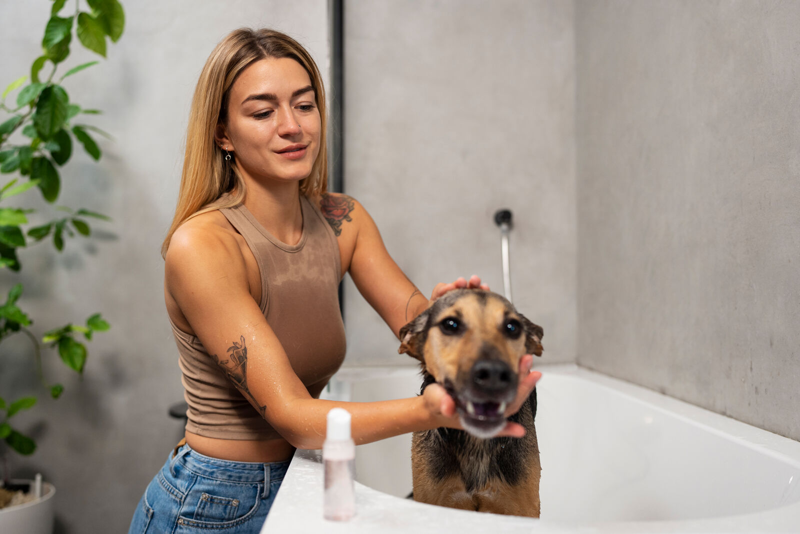 Kobieta kąpie psa w wannie