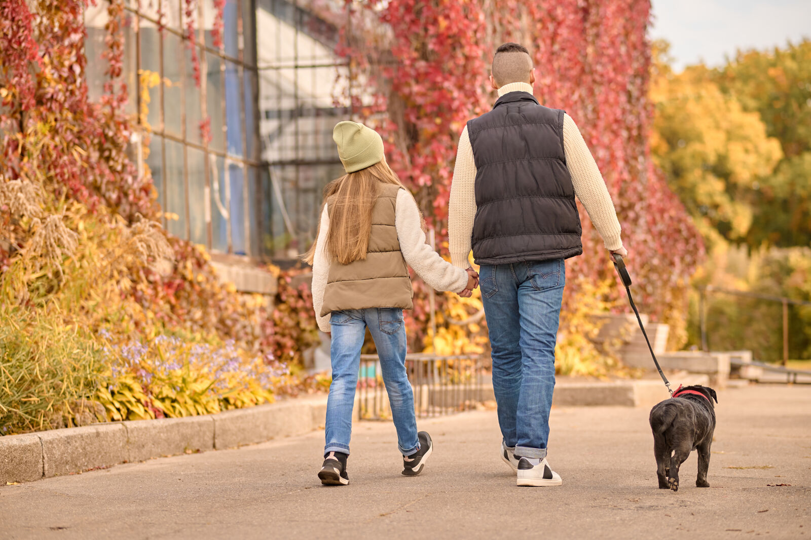 Mężczyzna z córką i psem są na spacerze.